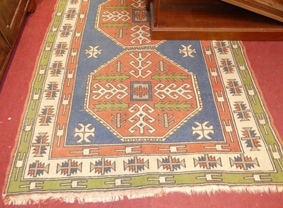 Lot 1179 - A Turkish woollen red ground rug, having twin...