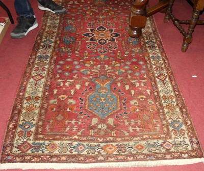 Lot 1181 - A Persian Star Ushak red ground hall rug, 230...