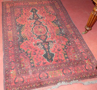 Lot 1188 - A Persian woollen red ground Shiraz rug, with...