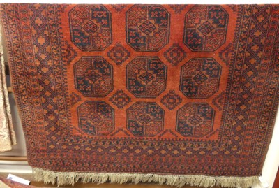 Lot 1189 - A Persian woollen red ground Bokhara rug,...