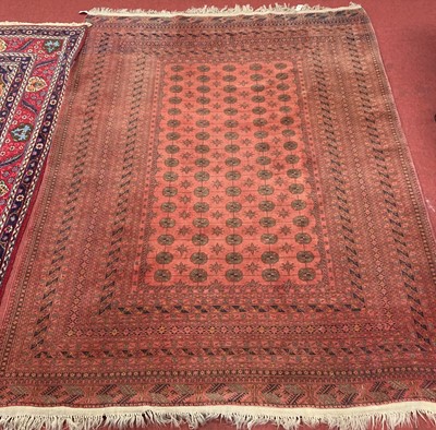 Lot 1196 - A Persian woollen red ground Bokhara rug, 300...