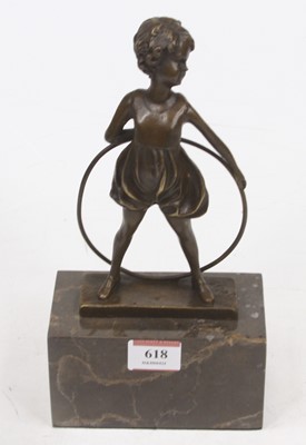 Lot 618 - A bronzed figure of a child, shown standing...