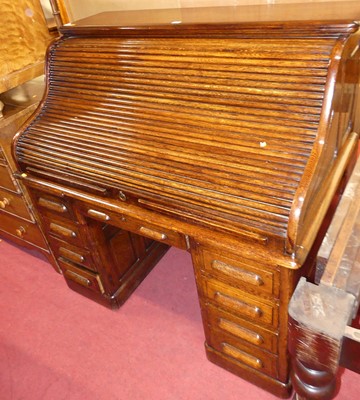 Lot 1433 - A 1930s oak kneehole roll-top desk, having a...