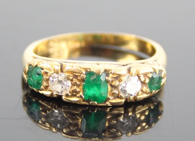 Lot 2653 - A yellow metal, emerald and diamond half...