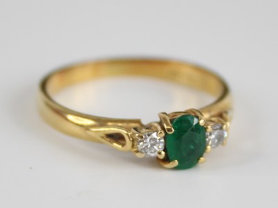 Lot 2533 - An 18ct gold, emerald and diamond three-stone...
