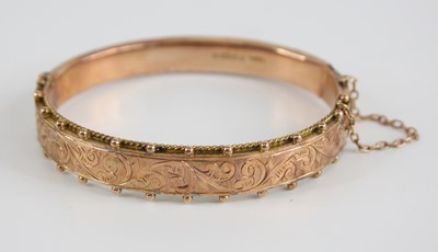 Lot 2536 - An Edwardian 9ct gold hinged hollow bangle,...