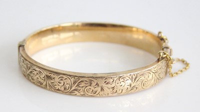 Lot 2836 - A 9ct yellow gold oval hinged hollow bangle,...