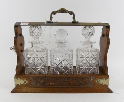 Lot 145 - An early 20th century oak three-decanter...