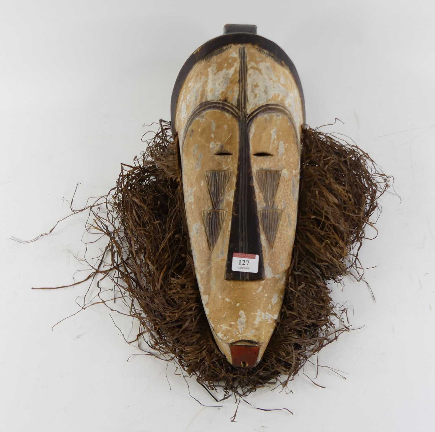Lot 127 - An African carved wood mask height 52cm