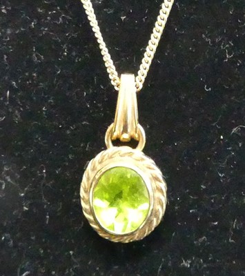 Lot 374 - A 9ct gold and green peridot set pendant, on...