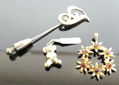 Lot 388 - A yellow metal garnet set flower head pendant,...