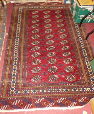 Lot 1154 - A Persian woollen red ground Bokhara rug,...