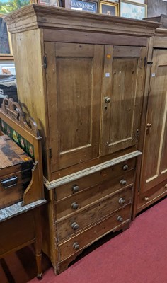 Lot 1217 - A rustic pine linen cupboard, the twin upper...
