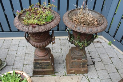 Lot 1411 - A pair of cast iron twin handled pedestal...