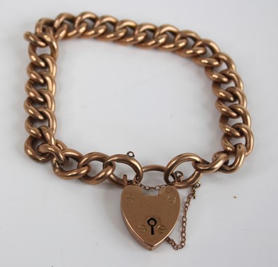 Lot 2864 - A 9ct gold curblink bracelet, with heart...