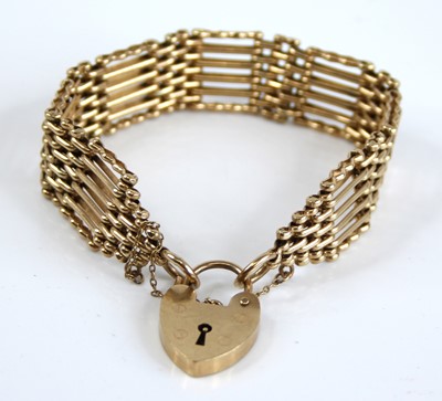 Lot 2401 - A 9ct gold gatelink bracelet, having heart...
