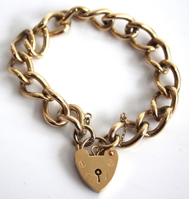Lot 2451 - A 9ct gold curblink bracelet, having heart...