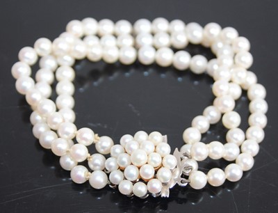 Lot 2437 - A cultured pearl three-string bracelet, the...