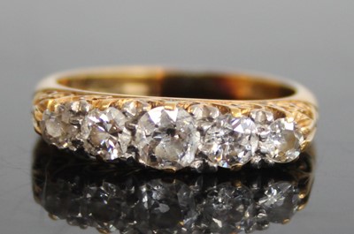 Lot 2465 - An 18ct gold diamond five-stone half hoop ring,...