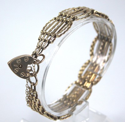 Lot 2485 - A 9ct gold gatelink bracelet, having heart...
