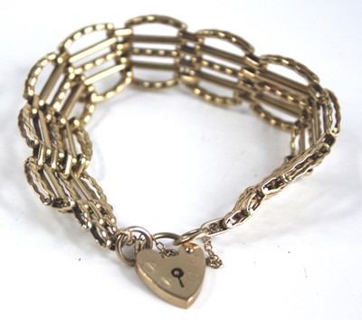 Lot 2485 - A 9ct gold gatelink bracelet, having heart...