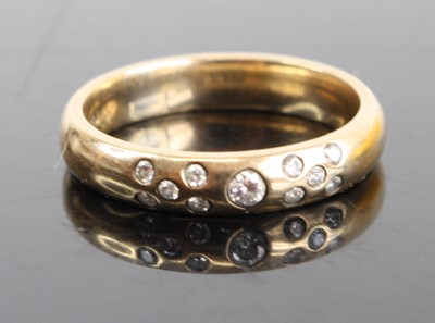 Lot 2797 - A 9ct gold diamond set band ring arranged as a...