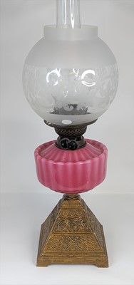 Lot 131 - A Victorian oil lamp, having a pink glass font...