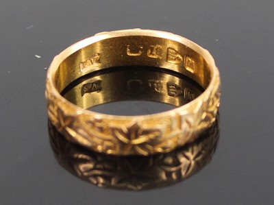 Lot 400 - An 18ct gold and engraved wedding band, 3.8g,...