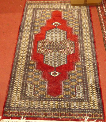 Lot 1179 - A Persian woollen red ground Bokhara rug, 200...