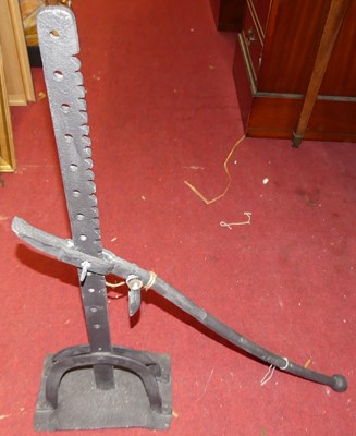 Lot 1090 - A black painted forged iron lever arm on stand