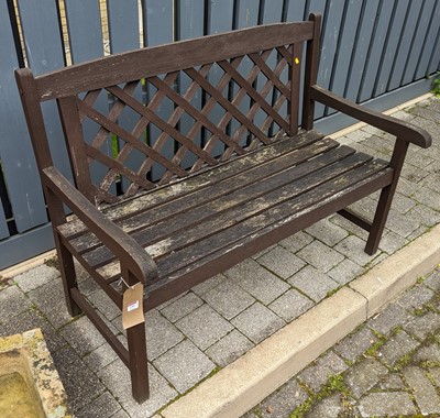 Lot 1391 - A stained teak slatted two-seater garden bench,...