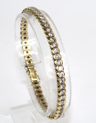 Lot 2231 - An 18ct gold diamond tennis bracelet,...