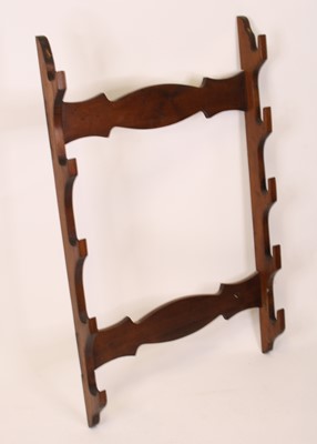 Lot 3480 - A wall mounted stained pine gun rack for five...