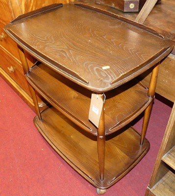 Lot 1148 - An Ercol dark elm three-tier tea trolley,...