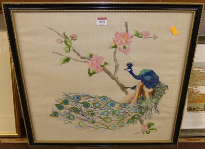 Lot 1034 - A framed silkwork panel depicting a peacock...