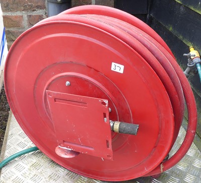 Lot 9 - A wall-mounted fire hose