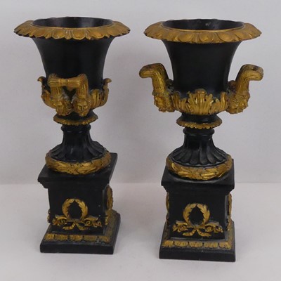 Lot 15 - A pair of black and gilt composite urns, of...