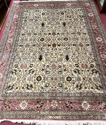 Lot 1166 - A Persian woollen cream ground Tabriz rug,...