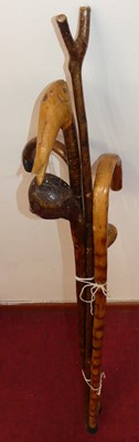 Lot 502 - A collection of six carved wood walking sticks,...