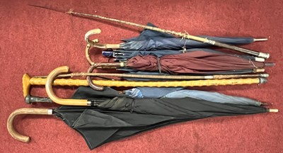 Lot 591 - A collection of walking sticks and umbrellas,...