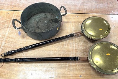 Lot 653 - A Victorian copper jam pan, flanked by brass...