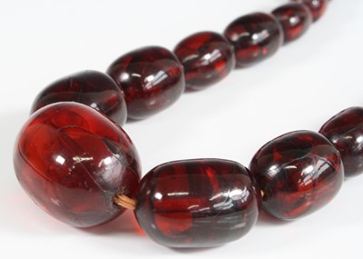 Lot 421 - A cherry amber necklace, arranged as 51...