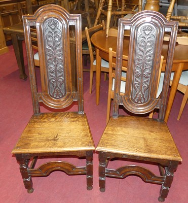 Lot 1350 - A pair of joined oak panelled seat hall chairs,...