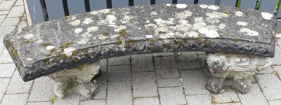 Lot 1446 - A reconstituted stone curved garden bench on...