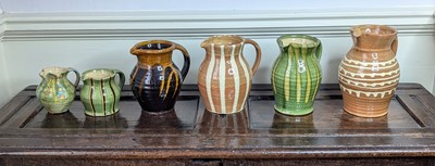 Lot 1019 - A collection of six studio pottery jugs, each...