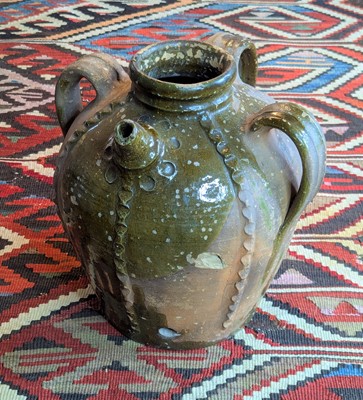 Lot 1024 - A French green glazed earthenware walnut oil...