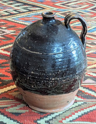 Lot 1027 - A black glazed earthenware flagon, 19th...