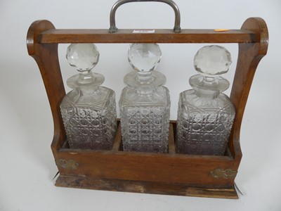 Lot 188 - An Edwardian oak three decanter tantalus,...