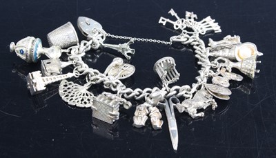 Lot 334 - A silver curb link charm bracelet together...