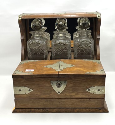 Lot 66 - An Edwardian oak three decanter tantalus,...